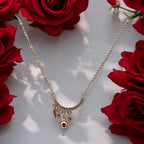 Gold-toned crescent moon pendant necklace with sparkling stones and star, bead and charm dangles, flat-lay with red roses