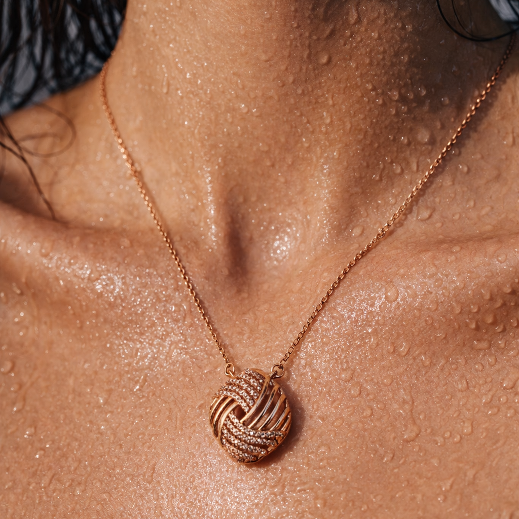 Rose gold necklace with a knot pendant on a person's neck