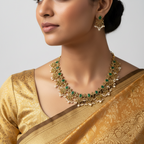 Antique gold Harita Haar necklace set with green stones and pearls, flat-lay on white tulle with roses