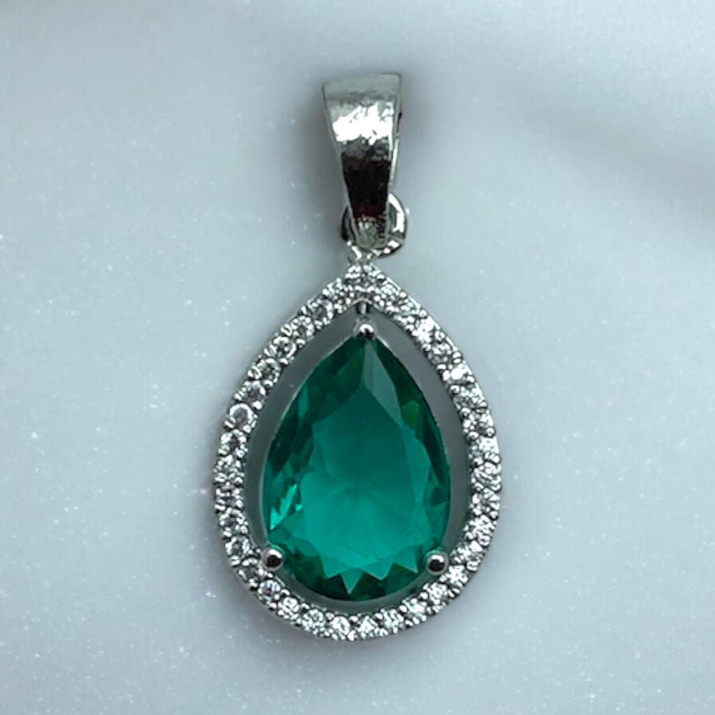 Silver-tone pear emerald pendant with clear stone halo, flat-lay close-up