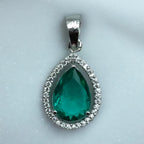 Silver-tone pear emerald pendant with clear stone halo, flat-lay close-up