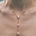 Rose gold necklace with clear gemstones on a person's neck