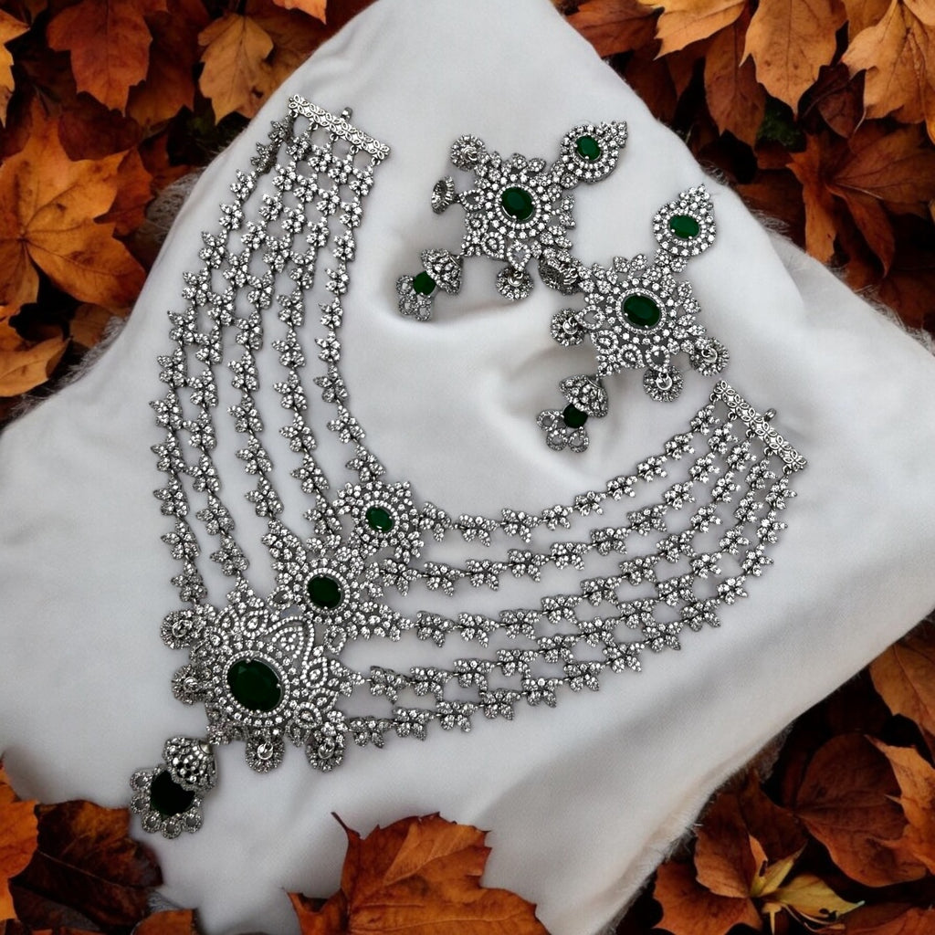 Silver-tone emerald & white stone necklace set with drop earrings, worn on model with blue saree