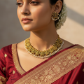 Antique gold temple necklace set with Lakshmi motifs and pearl drops, worn on model with matching studs