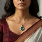 Silver-tone pear emerald pendant with clear stone halo, worn on model with saree