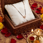 Wooden jewelry box with a necklace on a decorative table with rose petals and candles.