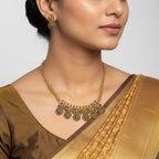 Antique gold temple necklace set with red and green kemp coin pendants and peacock studs, worn on model with saree