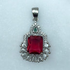 Silver-tone ruby-red pendant necklace with white-stone halo, worn on model with red saree