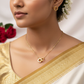 Gold-toned interlocked circle pendant necklace with textured detailing, shown on a display bust with red roses