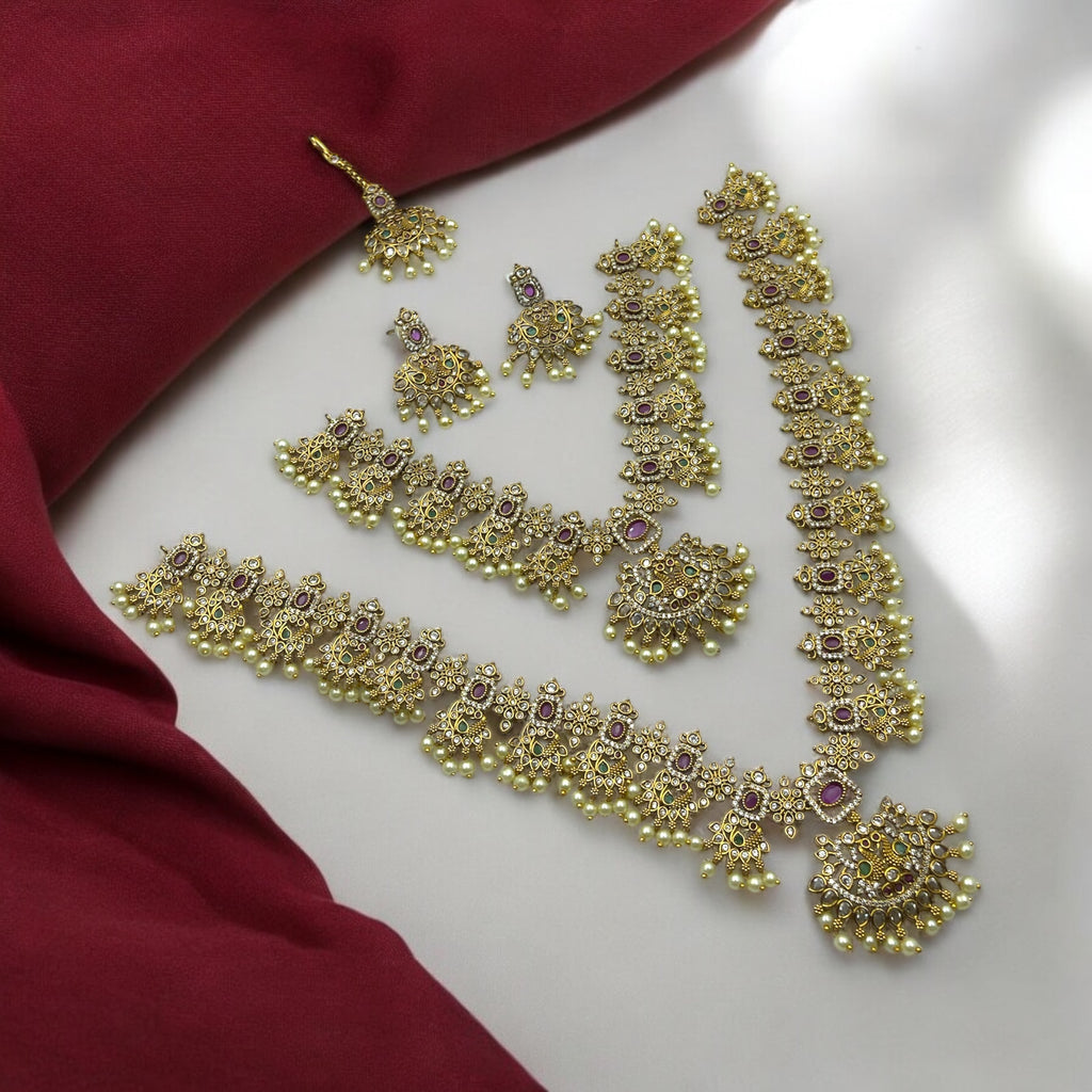 Antique gold bridal necklace set with ruby, emerald and crystal stones and pearl drops, layered necklace and choker worn on a model