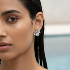 Silver-tone dewdrop crystal stud earring with petal accents, close-up worn on model's ear