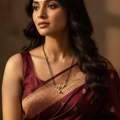 Gold-tone heartbeat mangalsutra with studded pendant and pearl drop, worn on-model with black beaded chain