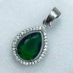 Silver-tone green pear pendant with clear-stone halo, worn on a chain by a woman in a cream saree