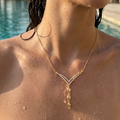 Woman wearing a gold necklace by a poolside