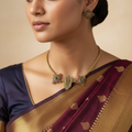 Antique gold temple necklace set with Hamsa hand and sunburst motifs, worn on model with matching stud earring