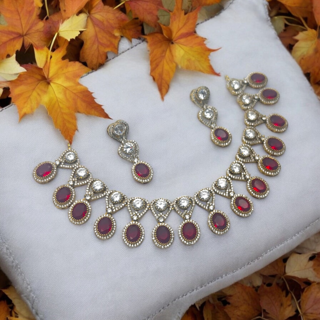 Gold-plated red and white stone statement necklace set with earrings, flat-lay with autumn leaves