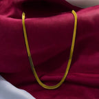 Gold-tone herringbone chain necklace, sleek flat design worn on-model at the neckline