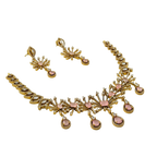 Gold necklace with pink stones on a white background
