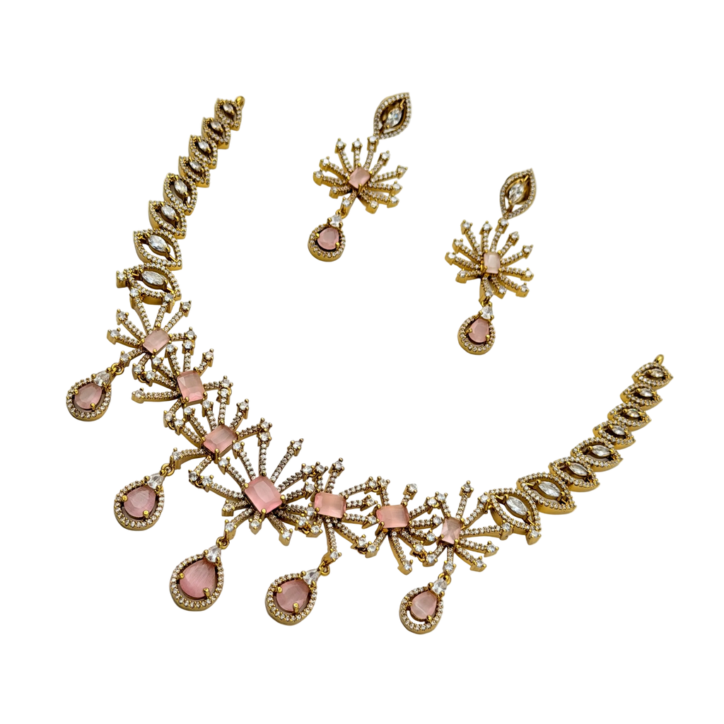 Gold and pink jewelry set with necklace and earrings on a white background