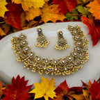 Antique gold Kundan necklace set with white stones and pearl drops, worn by a model in a gold saree