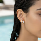 Gold-tone butterfly stud earring with pave crystal wings, close-up on model's ear
