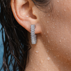 Silver baguette crystal curved hoop earring with edge-to-edge sparkle, close-up on-ear shot showing fit and shine