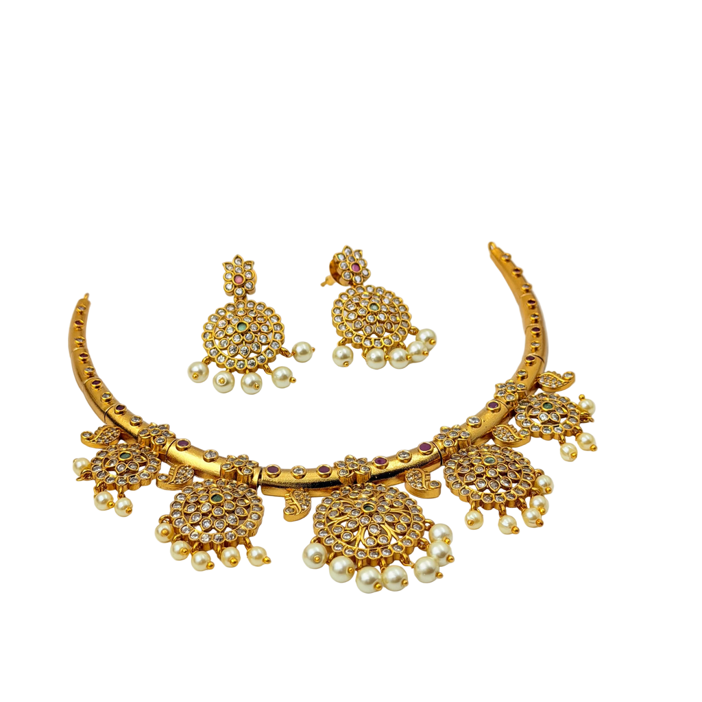 Gold jewelry set with necklace, earrings, and ring on a white background