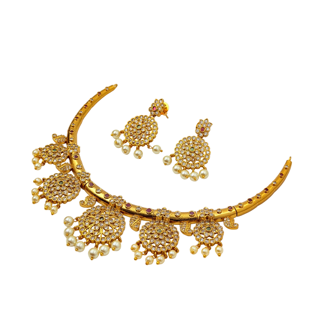 Gold necklace and earrings set on a white background