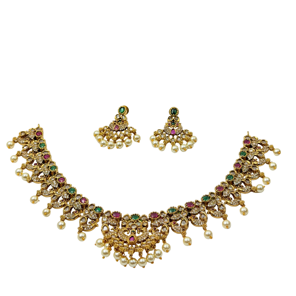Gold necklace with pearls and gemstones on a white background