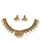 Gold necklace with pearls and gemstones on a white background