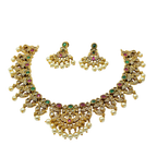 Gold necklace and earrings set with pearls and gemstones on a white background