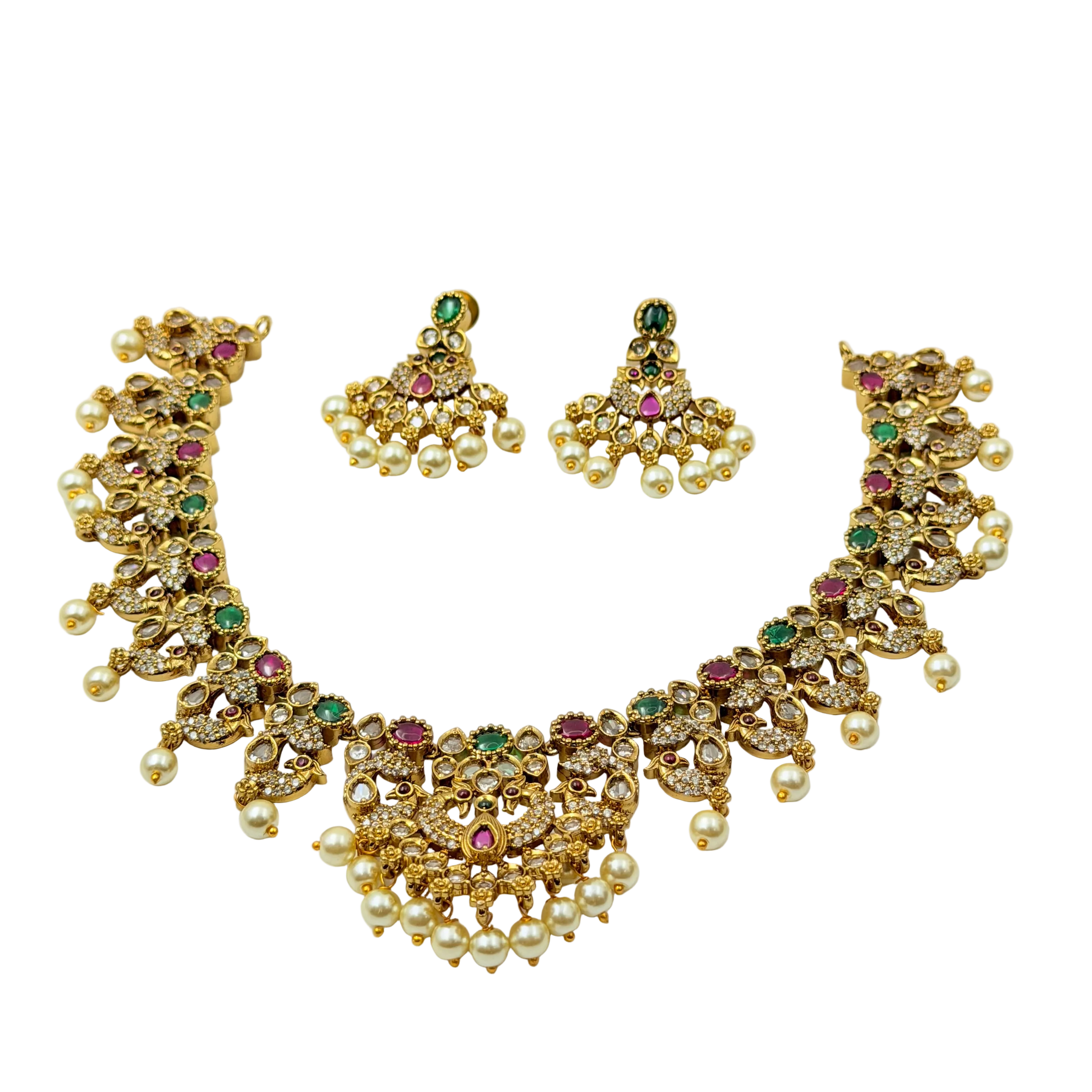 Gold necklace and earrings set with pearls and gemstones on a white background