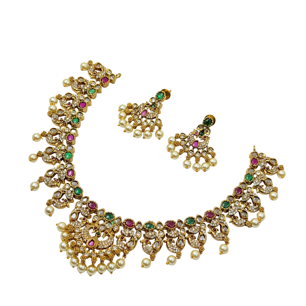Gold necklace and earrings set with gemstones on a white background