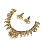 Gold necklace and earrings set with gemstones on a white background