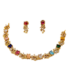 Gold necklace and earrings set with multicolored gemstones on a white background
