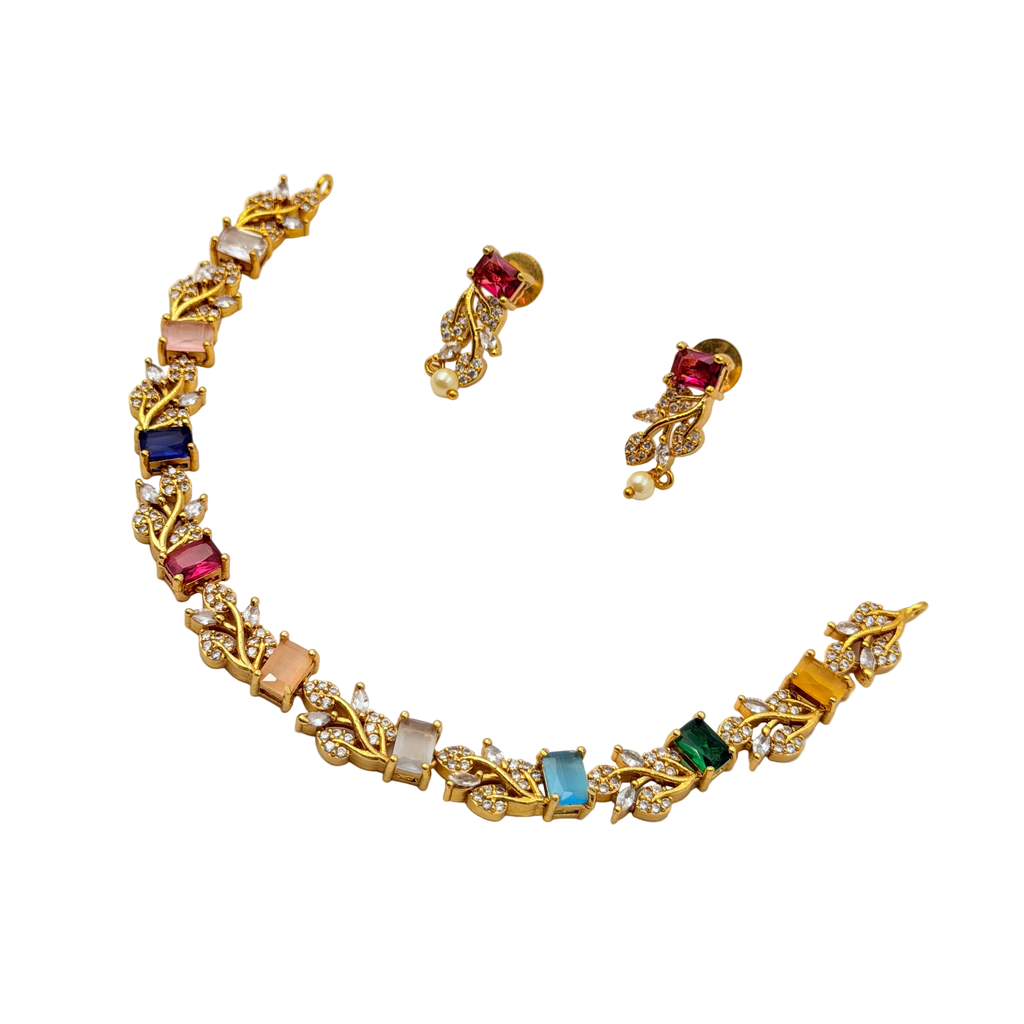 Gold necklace with colorful gemstones and matching earrings on a white background