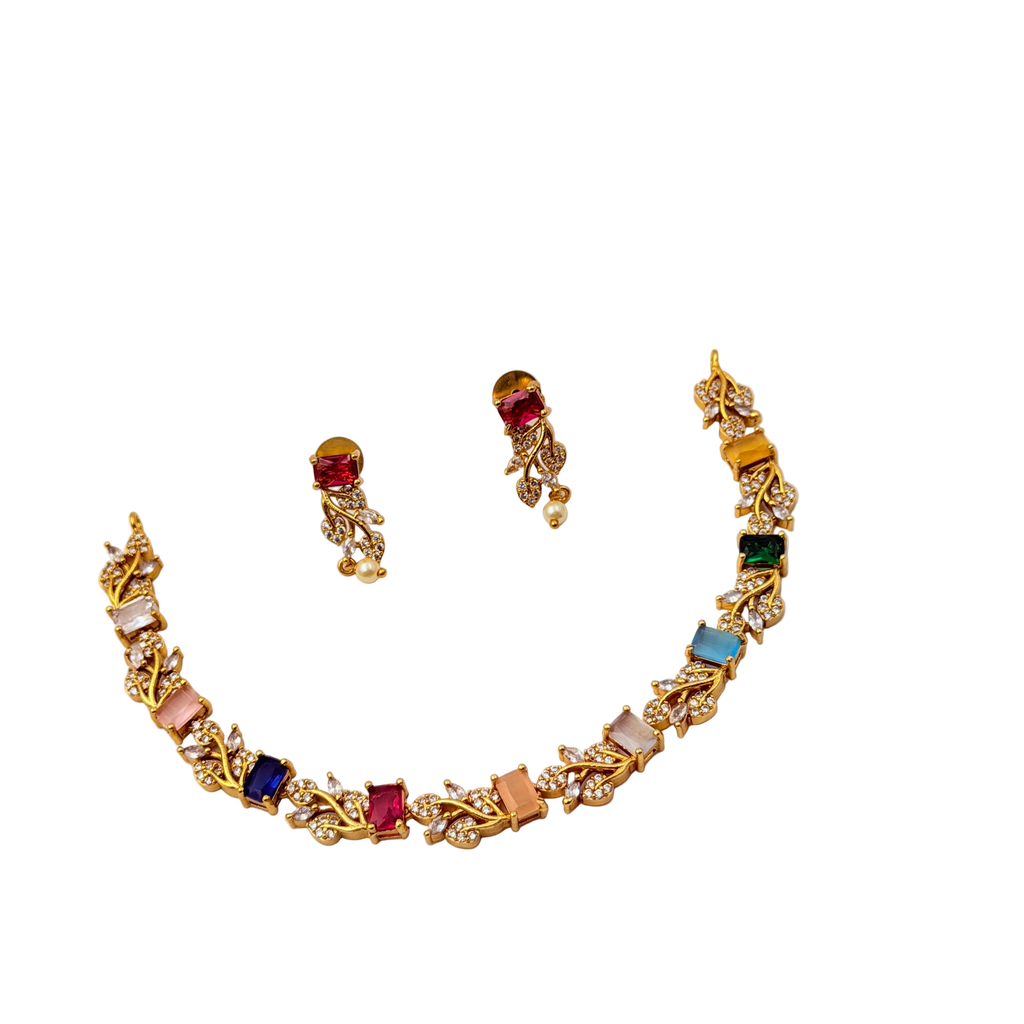 Gold necklace with colorful gemstones and matching earrings on a white background