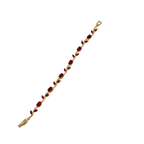 Gold bracelet with red stones on a white background