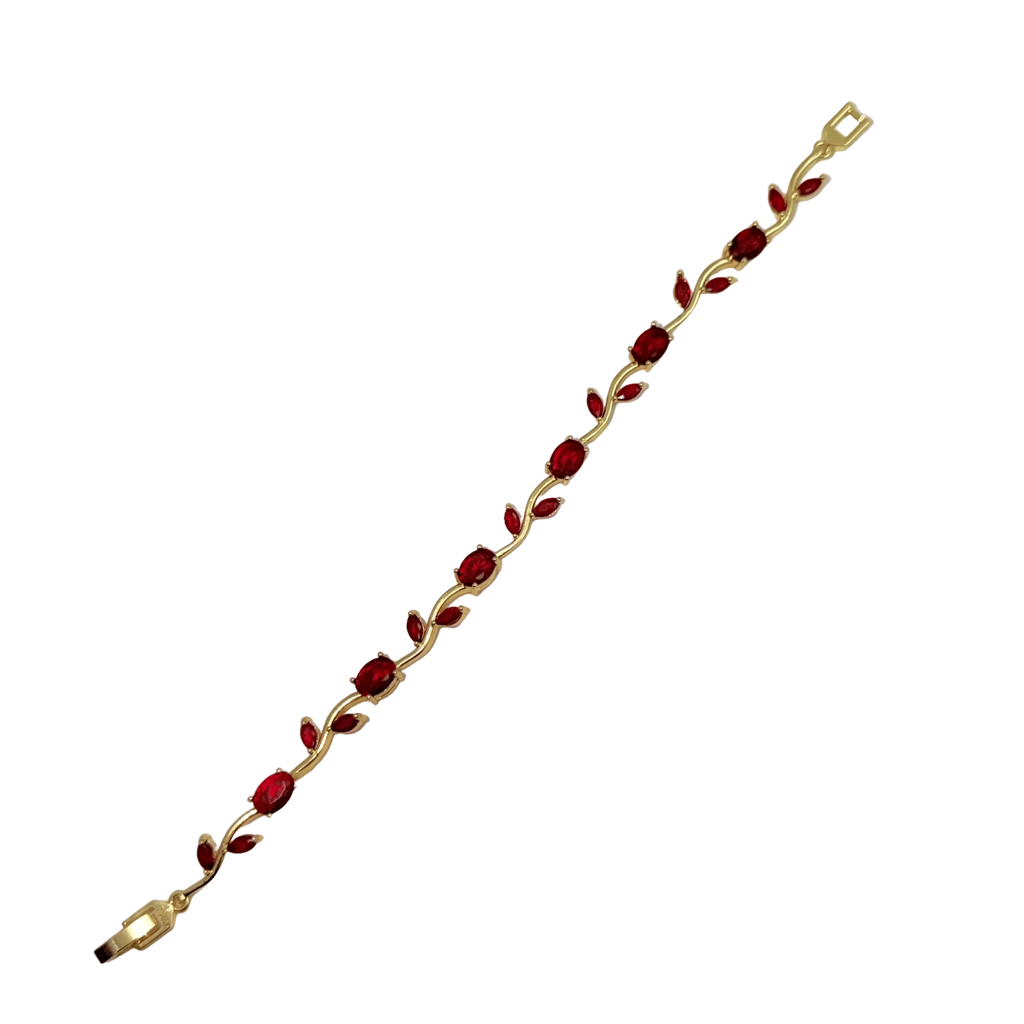 Gold bracelet with red stones on a white background