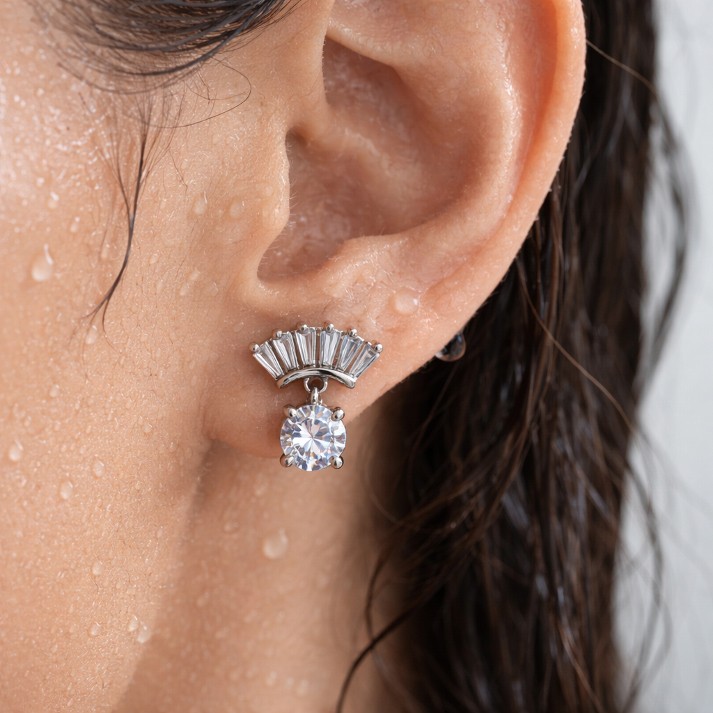 Close-up of an ear wearing a silver earring with a round gemstone.