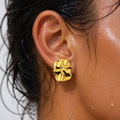 Gold earring worn by a person with wet hair.