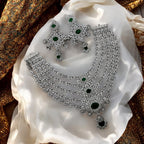 Silver-tone emerald & white stone multi-layered necklace set with earrings, flat-lay on cream festive fabric