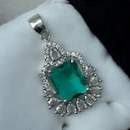 Silver-tone green emerald-cut halo pendant with CZ accents, worn on a model with a navy saree