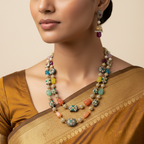 Antique gold-toned multicolour beaded necklace set with jhumka earrings, worn by model over a silk saree