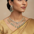 Gold-plated seagreen pear-drop AD necklace set with matching earrings, worn on model in gold saree