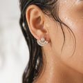 Close-up of an ear wearing a diamond earring with a blurred background