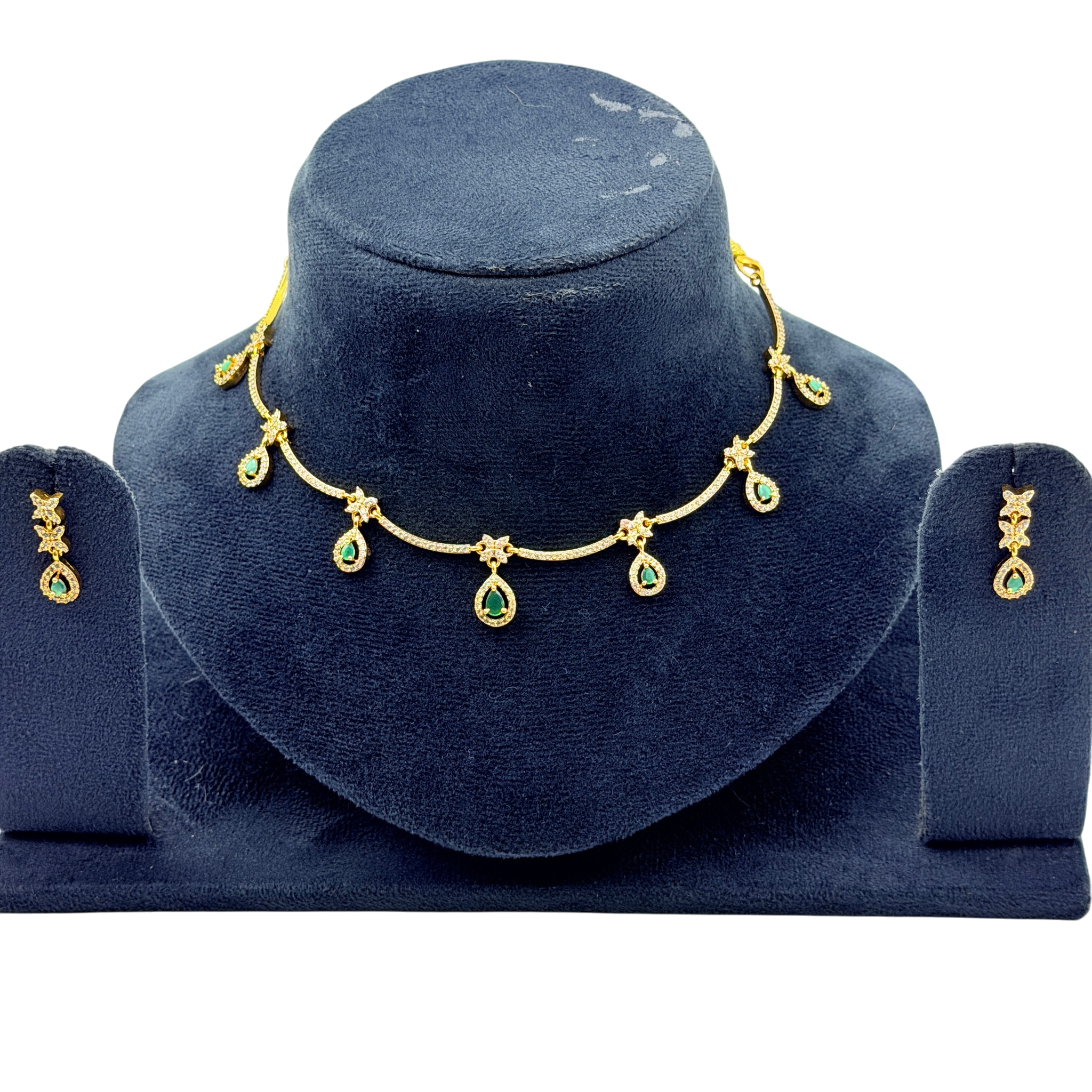 Gold necklace with green gemstones on a blue velvet stand