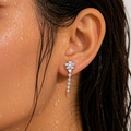 Close-up of an ear wearing a floral earring with a blurred background