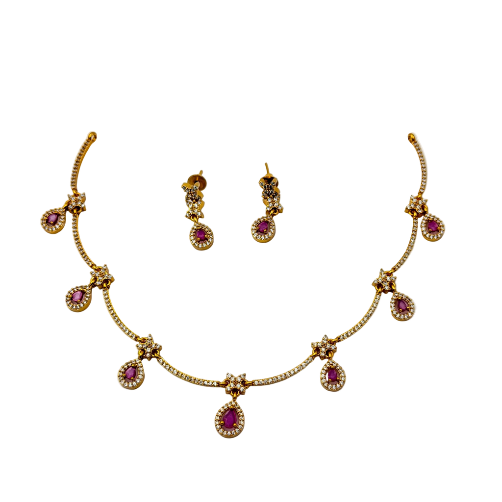 Gold necklace with pink gemstones and matching earrings on a white background