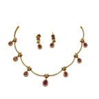 Gold necklace with pink gemstones and matching earrings on a white background